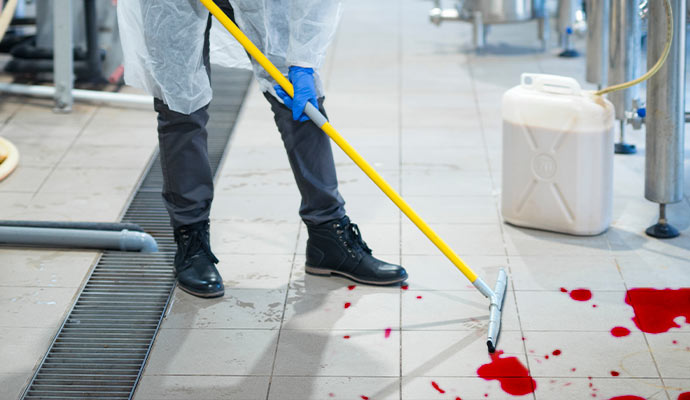 professional biohazard cleaner in protective uniform cleaning floor
